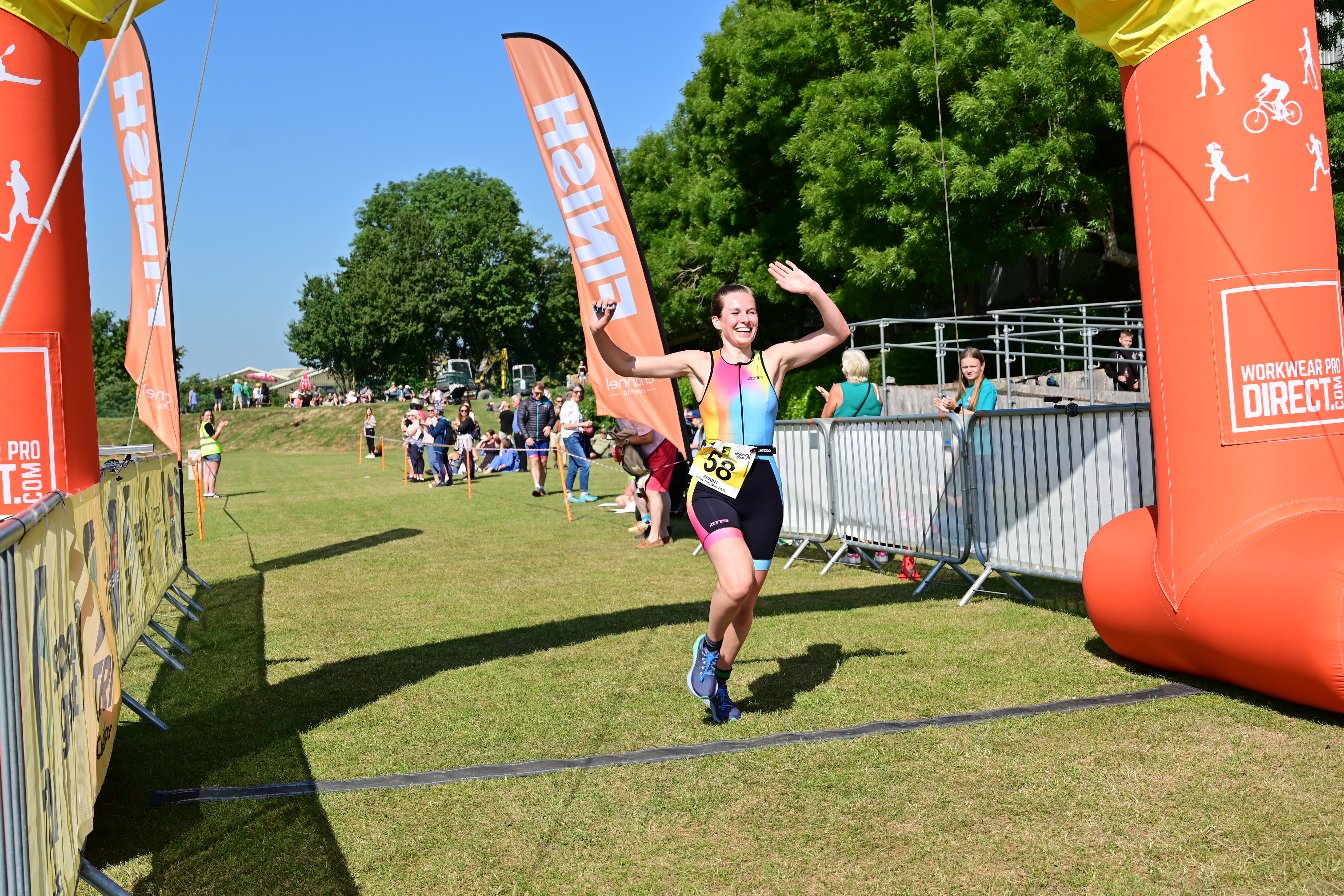 Finisher celebrating at the TriCheddar finish line, wearing official race kit