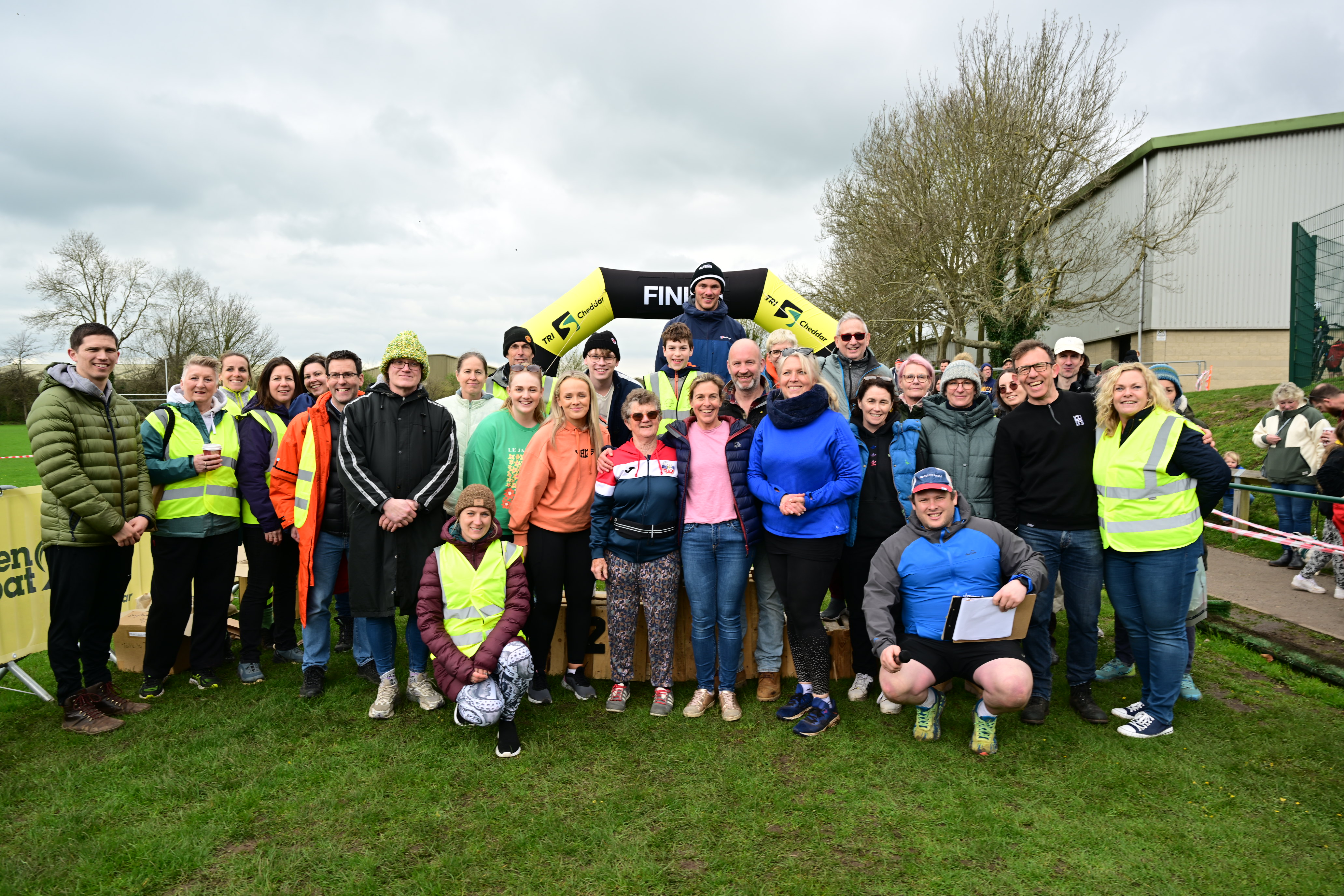 Group of smiling TriCheddar volunteer marshals in hi-vis at Kings of Cheddar